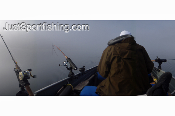 Fisherman in a boat surrounded by fog.